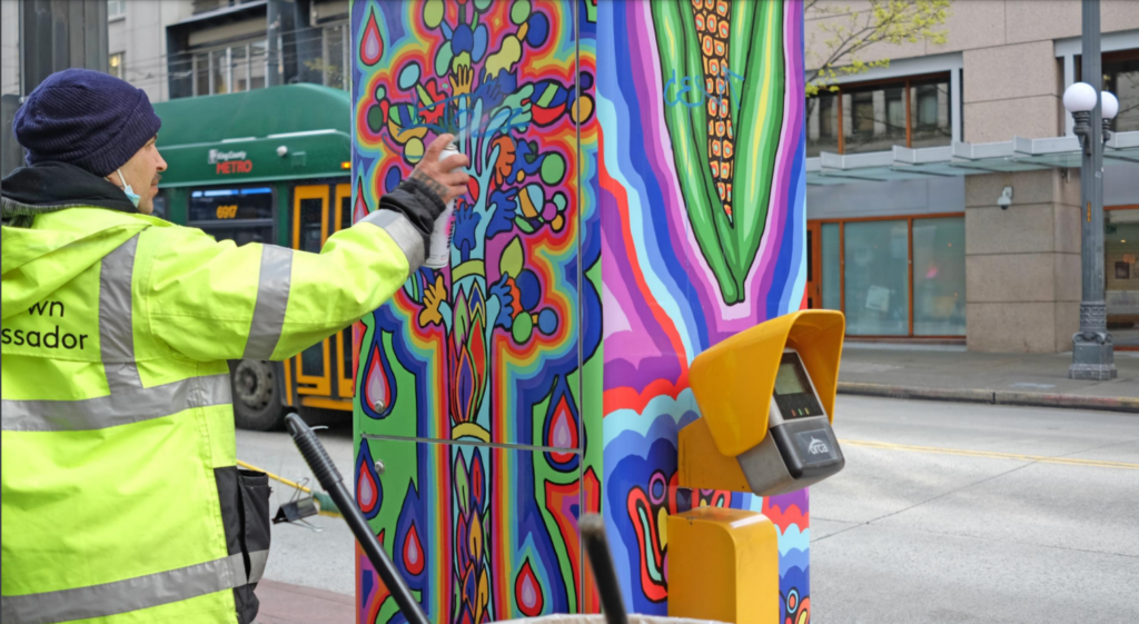 A downtown ambassador cleans graffiti
