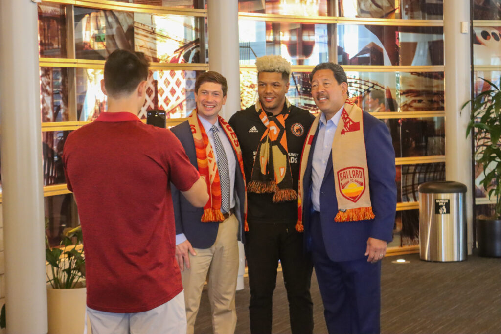 Members of the Ballard FC organization take pictures with Councilmember Dan Strauss and Mayor Bruce Harrell. 