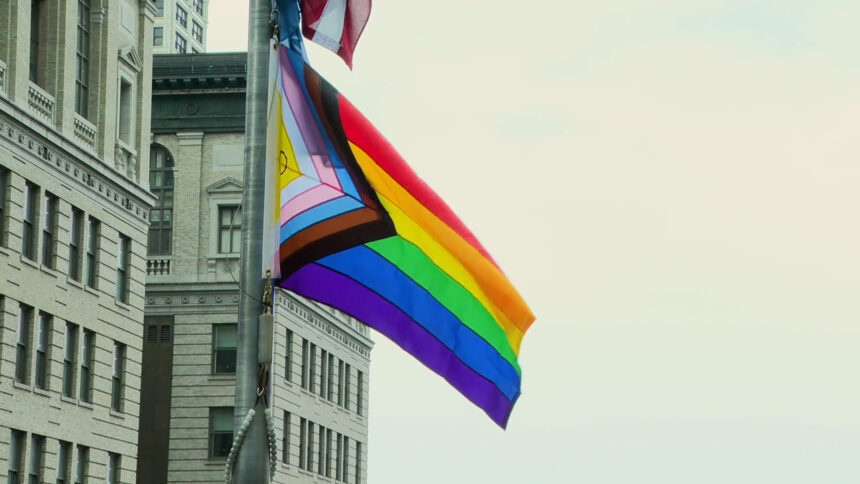 Pride Flag waving in the sky at City Hall