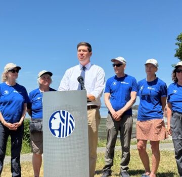 councilmember Strauss speaking at an outdoor press conference on bight sunny day with blue skies