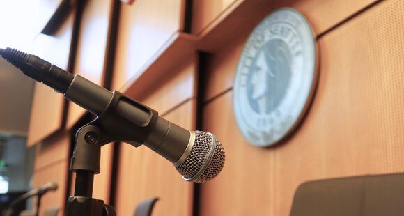 Vacancy_630x310 microphone at Seattle City Hall Chambers, the official City of Seattle seal can be seen in the background