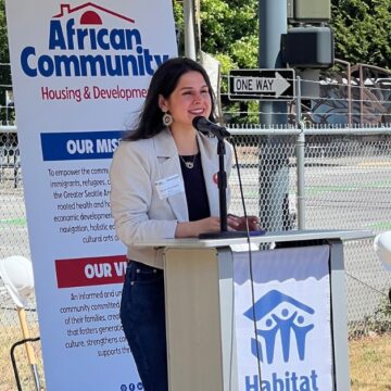 Councilmember Rinck speaking at a podium with the Habitat for Humanity logo