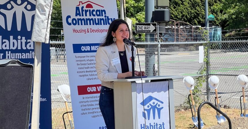 Councilmember Rinck speaking at a podium with the Habitat for Humanity logo