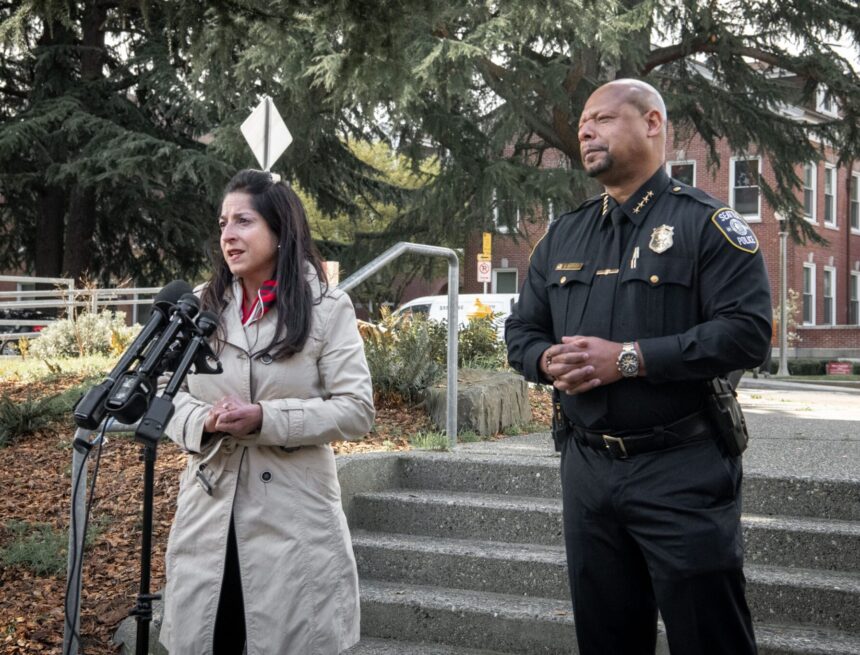 councilmember Rivera speaking into microphones with Police Chief Barnes standing next to her