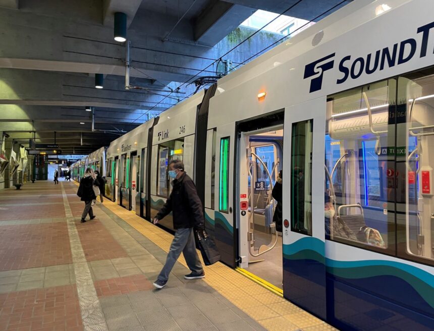 People get on and off an existing Sound Transit light rail train in Seattle
