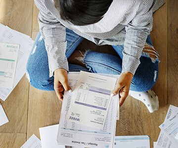 person sitting on floor looking at invoices