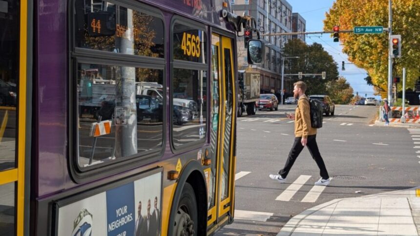 SDOT Bus bus stopped in front of a crosswalk as a person walks across