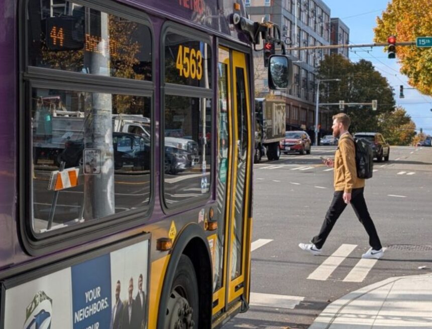 bus stopped in front of a crosswalk as a person walks across