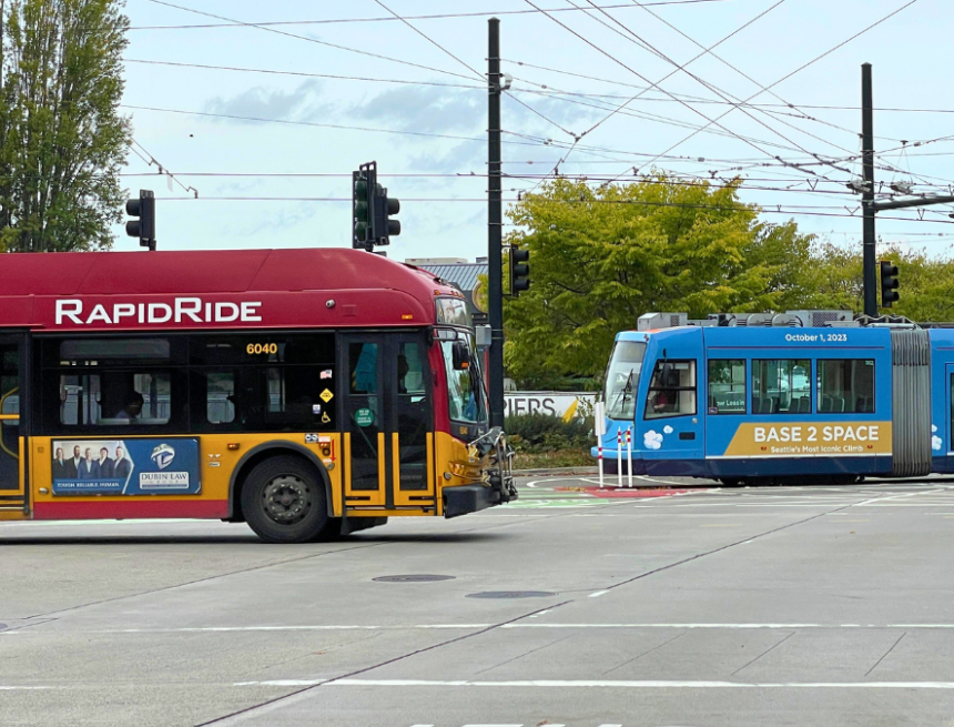 A Red bus and a blue streetcar moving in opposite directions